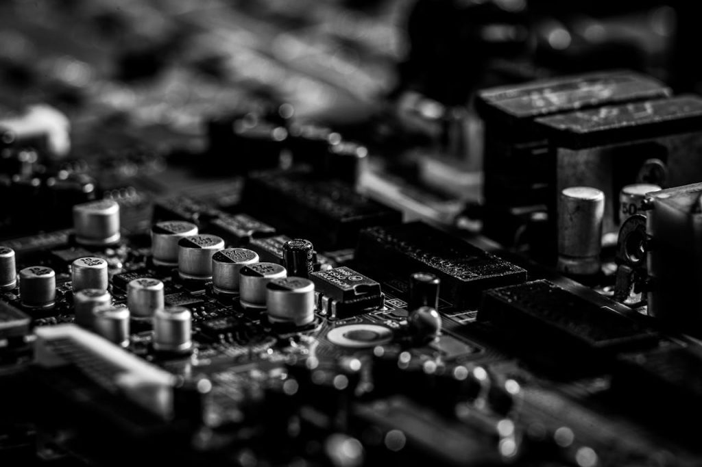 Close-up view of a printed circuit board (PCB) showing capacitors and electronic components in black and white.